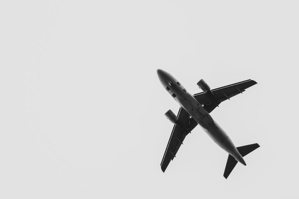 A black and white image of an airplane flying from below, captured over France.